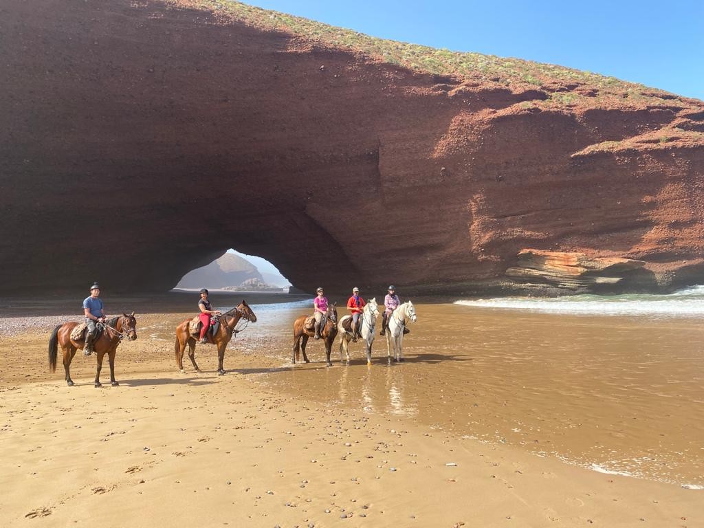 Horse riding on the beach at sunset